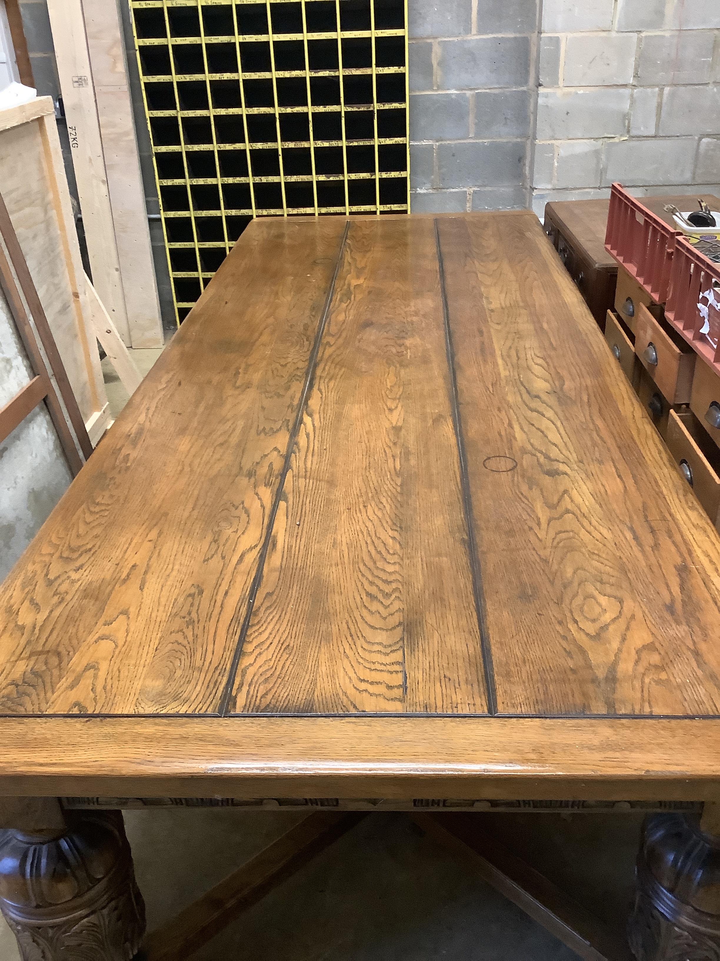 A very large 17th century style oak refectory dining table, with cleated three plank top on carved baluster legs, length 305cm, depth 120cm, height 76cm